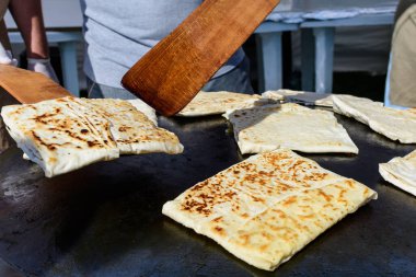 Et ya da peynirle doldurulmuş ve levha demirinde pişirilmiş düz ekmekten yapılmış olan gözleme adlı geleneksel Türk yemeği, bir sokak gıda pazarında satılmaya hazırlanıyor.