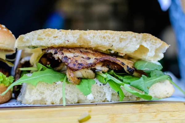 Lezzetli bir sandviçe yakın, roka ve mantarlı ızgara baharatlı et, hafta sonu sokak yiyecek pazarında satılıyor.