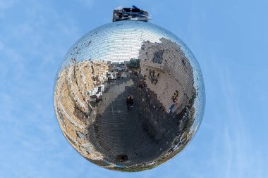 Güneşli bir günde disko ayna topu, aşağıdan aydınlık bulutlu mavi gökyüzüne doğru görüş