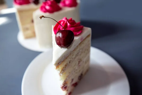 Ağız sulandıran kirazlı cheesecake makrosu çatallı. Mavi arka grond 'da çekilen