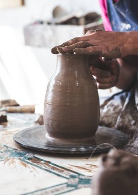 Çömlek çarkında çamurdan yapılmış Potter elleri. Potter çömlek çarkında yapıyor.