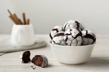 Beyaz tabakta lezzetli çikolatalı bisküviler. Beyaz tahta bir masada ev yapımı kurabiyeler..