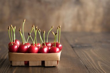 Dikdörtgen bir huş sepetinde olgun kirazlar.