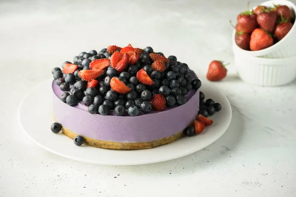 Makanan penutup mentah. Berry vegan cheesecake tanpa dipanggang. Makanan penutup dengan buah-buahan segar di piring putih. — Stok Foto