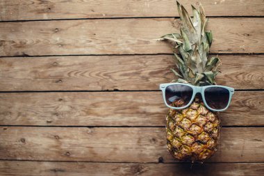 Eski ahşap bir masada, gözlüklü olgun ananas, gözlüklü ananas