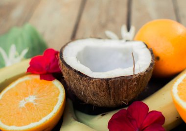 Ahşap arka planda tropik meyve. Meyve arka planı. Tahta bir masada hindistan cevizi, portakal ve muz.