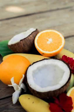 Ahşap arka planda tropik meyve. Meyve arka planı. Tahta bir masada hindistan cevizi, portakal ve muz.