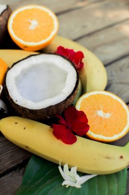 Ahşap arka planda tropik meyve. Meyve arka planı. Tahta bir masada hindistan cevizi, portakal ve muz.