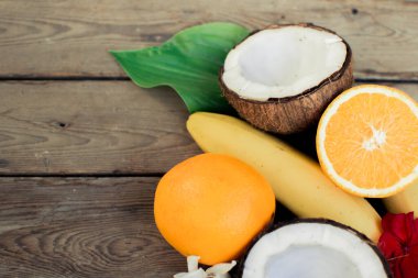 Ahşap arka planda tropik meyve. Meyve arka planı. Tahta bir masada hindistan cevizi, portakal ve muz.