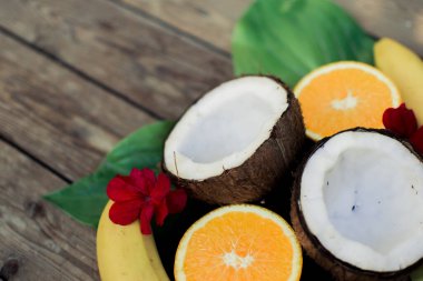 Ahşap arka planda tropik meyve. Meyve arka planı. Tahta bir masada hindistan cevizi, portakal ve muz.