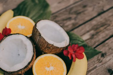 Ahşap arka planda tropik meyve. Meyve arka planı. Tahta bir masada hindistan cevizi, portakal ve muz.