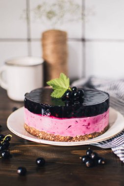 Siyah üzümlü peynirli kremalı kek. Tahta bir masada meyveli lezzetli bir pasta..