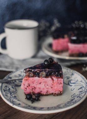 Siyah üzümlü peynirli kremalı kek. Tahta bir masada meyveli lezzetli bir pasta..