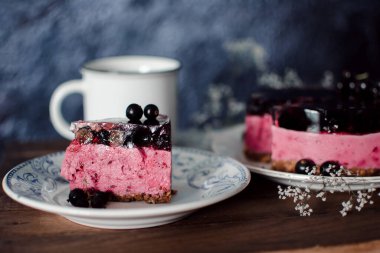 Siyah üzümlü peynirli kremalı kek. Tahta bir masada meyveli lezzetli bir pasta..