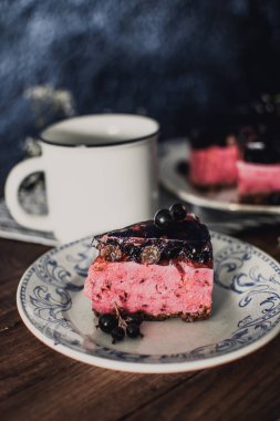 Siyah üzümlü peynirli kremalı kek. Tahta bir masada meyveli lezzetli bir pasta..
