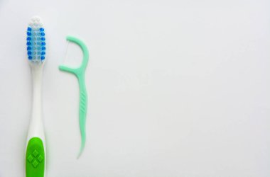 Diş fırçası ve diş ipi beyaz arkaplanda izole edildi, kopyalama alanı