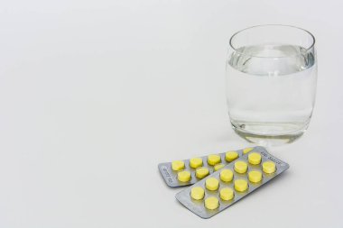 pills of medicine with glass of drinking water isolated on white background, copy space clipart