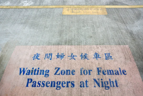 waiting zone for female passengers at night text sign painted on cement floor with pink background in train platform or railway station, Taipei, Taiwan