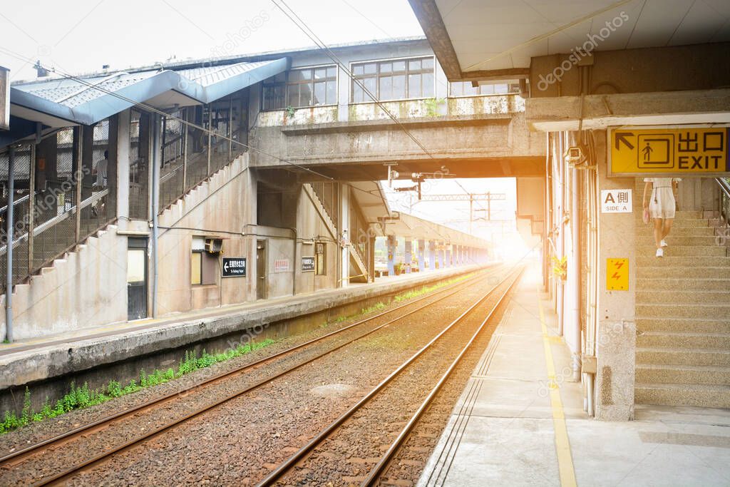 vintage train platform, railway station, building for crossing railroad tracks with sunset background, Taiwan