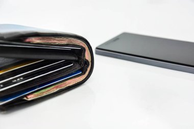 Kahverengi erkek cüzdanı ve cep telefonu beyaz arka planda, teknoloji çevrimiçi bankacılık para transferi, e-ticaret konsepti, kopyalama alanı (seçici odak alanı))