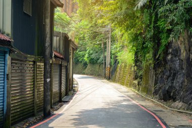 Kırsal bir köyde asfalt yol kıvrımlı. Sabah güneş ışığı var, Wulai, Tayvan.