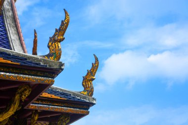 Tayland çatı mimarisi, mavi gökyüzü ve bulutların arka planında bulunan eğimli bir geçidin eğimli kenarlarındaki haghgss çıkıntıları, kopyalama alanı