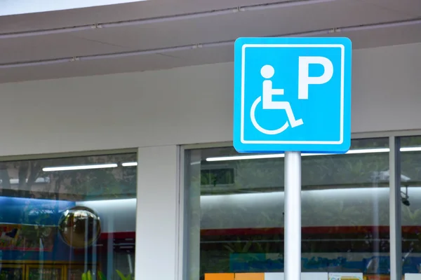 Blaues Behindertenschild Markiert Parkplatz Behindertenparkausweisschild Mast Mit Lebensmittelgeschäft Tankstellenbereich Hintergrund — Stockfoto