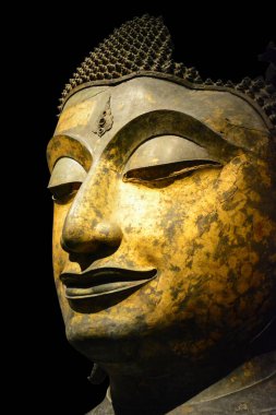 Kırpma yolu, antika bronz Buddha yüzüne yakın siyah arkaplanda izole edilmiş, kopyalama alanı (seçici odak)