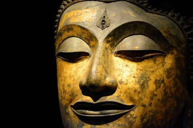 Kırpma yolu, antika bronz Buddha yüzüne yakın siyah arkaplanda izole edilmiş, kopyalama alanı (seçici odak)