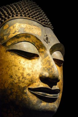 Kırpma yolu, antika bronz Buddha yüzüne yakın siyah arkaplanda izole edilmiş, kopyalama alanı (seçici odak)
