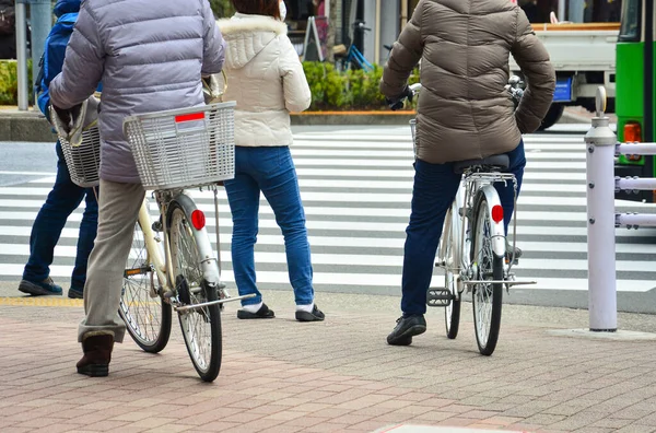 스러운 자전거와 보행자를 교차로에 얼룩말이 횡단하는 건너라는 신호를 기다리고 사람의 — 스톡 사진