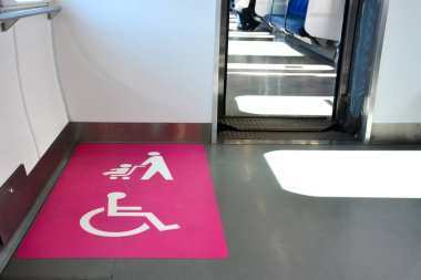 Demiryollarında, beyaz engelli bebek arabalarında ve pembe arka planda bebek arabası tabelasında engelliler için alan alanı, kopyalama alanı