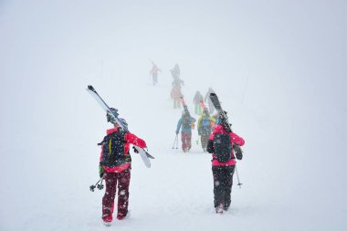 Bir grup kayakçı kış günü Japonya 'nın Hokkaido kentinde Asahi Dağı' nda (Asahidake Dağı) kayak yapmak için piste kayak ve ekipman taşır.