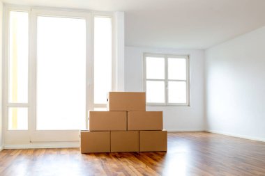 Moving Boxes In An Empty Apartment Against A White Wall clipart
