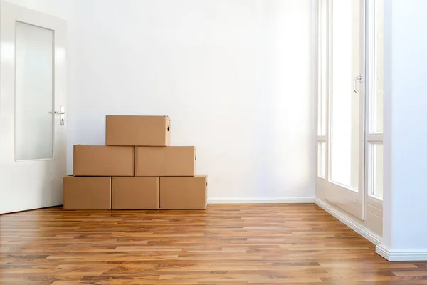 Moving Boxes In An Empty Apartment Against A White Wall