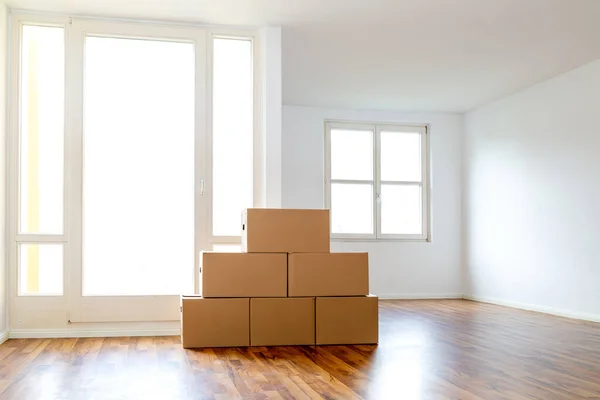 Moving Boxes In An Empty Apartment Against A White Wall