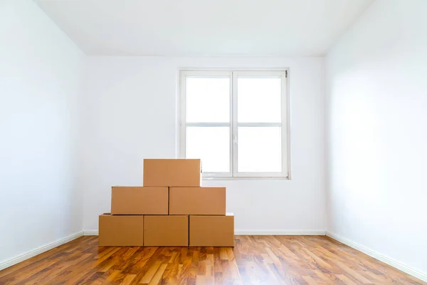 Moving Boxes In An Empty Apartment Against A White Wall