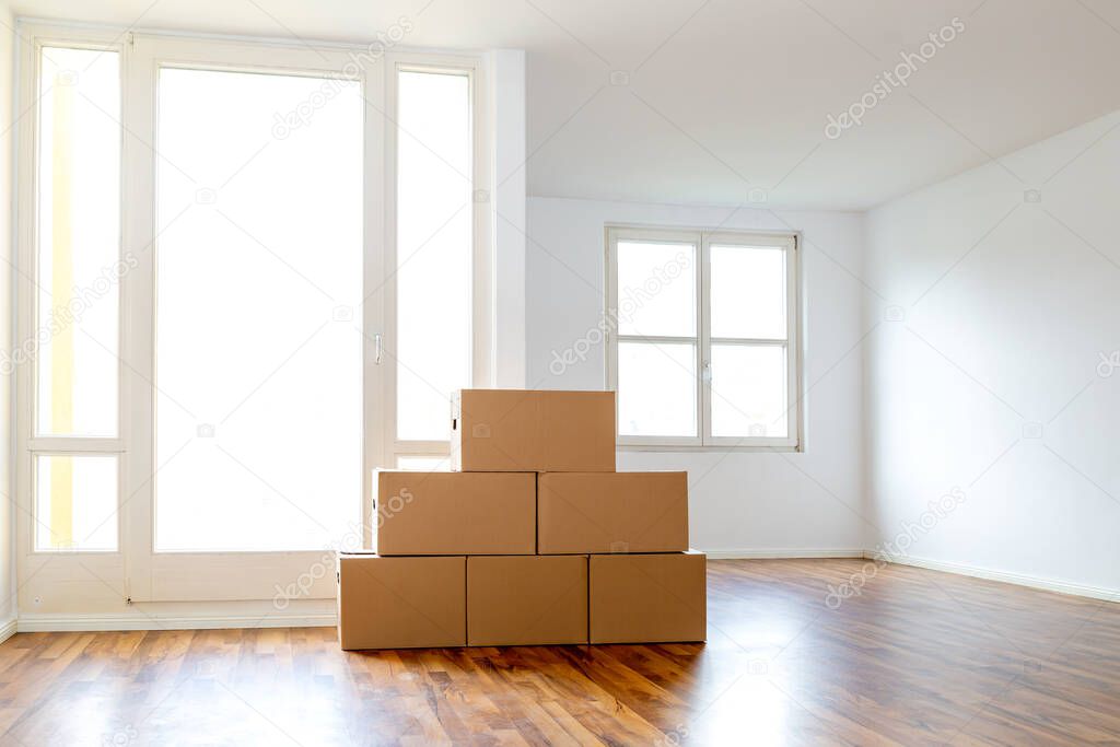 Moving Boxes In An Empty Apartment Against A White Wall