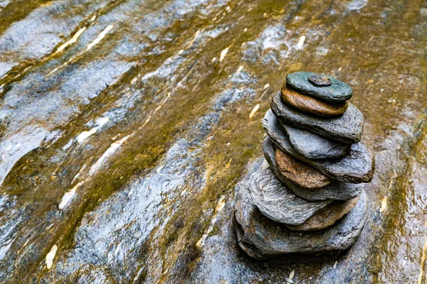 stacked flat stones on a wet stone plate