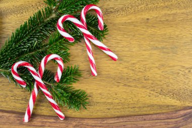 Tahtanın üzerinde dört şeker kamışı ve köknar dalı var.