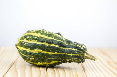 Dekoratif bir balkabağı (cucurbita) bir metin için arka plan ile tahta üzerinde uzanır