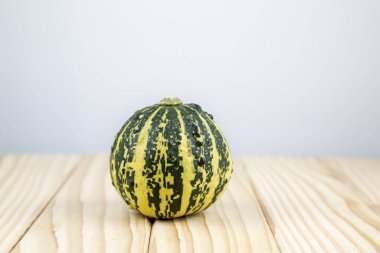 Dekoratif bir balkabağı (İtalyan Çizgisi) bir metin için arka planda tahtada yatar