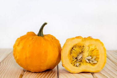 Dilimlenmiş bir balkabağı tahtanın üzerinde yatıyor.