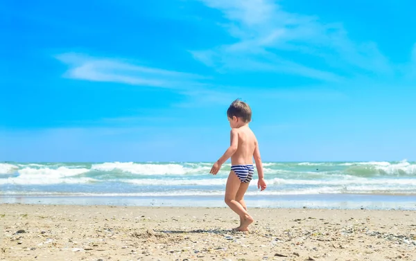 男の子が海岸を歩いている 熱帯のビーチで子供 砂と水は楽しいです 若い子供のための太陽の保護 — ストック写真