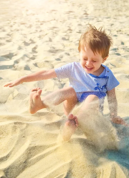 喜びの少年は海の砂で遊ぶ — ストック写真