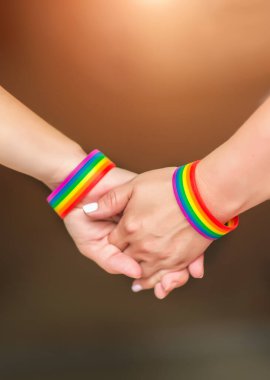 LGBT kadınlarının elleri gökkuşağı kurdele sembolü ile bir arada duruyor; LGBT gururu kavramı, LGBTQ insanları, lgbt hakları kampanyası