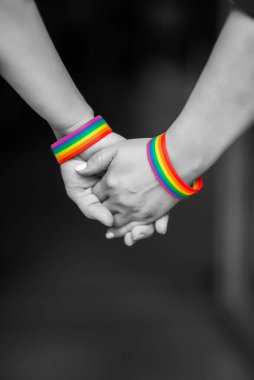 Gökkuşağı kurdele sembolü, LGBT gururu konsepti, LGBTQ insanları, lgbt hakları kampanyası ile bir arada tutan LGBT kadınlarının eli. Siyah ve Beyaz Fotoğraflar 