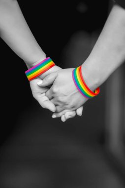 Gökkuşağı kurdele sembolü, LGBT gururu konsepti, LGBTQ insanları, lgbt hakları kampanyası ile bir arada tutan LGBT kadınlarının eli. Siyah ve Beyaz Fotoğraflar 