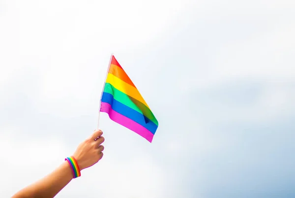 Mano Indossando Braccialetto Gay Pride Con Bandiere Arcobaleno Contro Cielo — Foto Stock