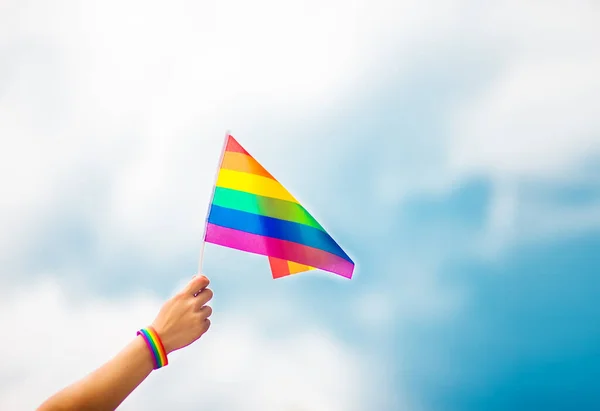 空に虹の旗をつけたゲイのプライドブレスレットを手に Lgbtの人々 同性間の関係 同性愛の概念 — ストック写真